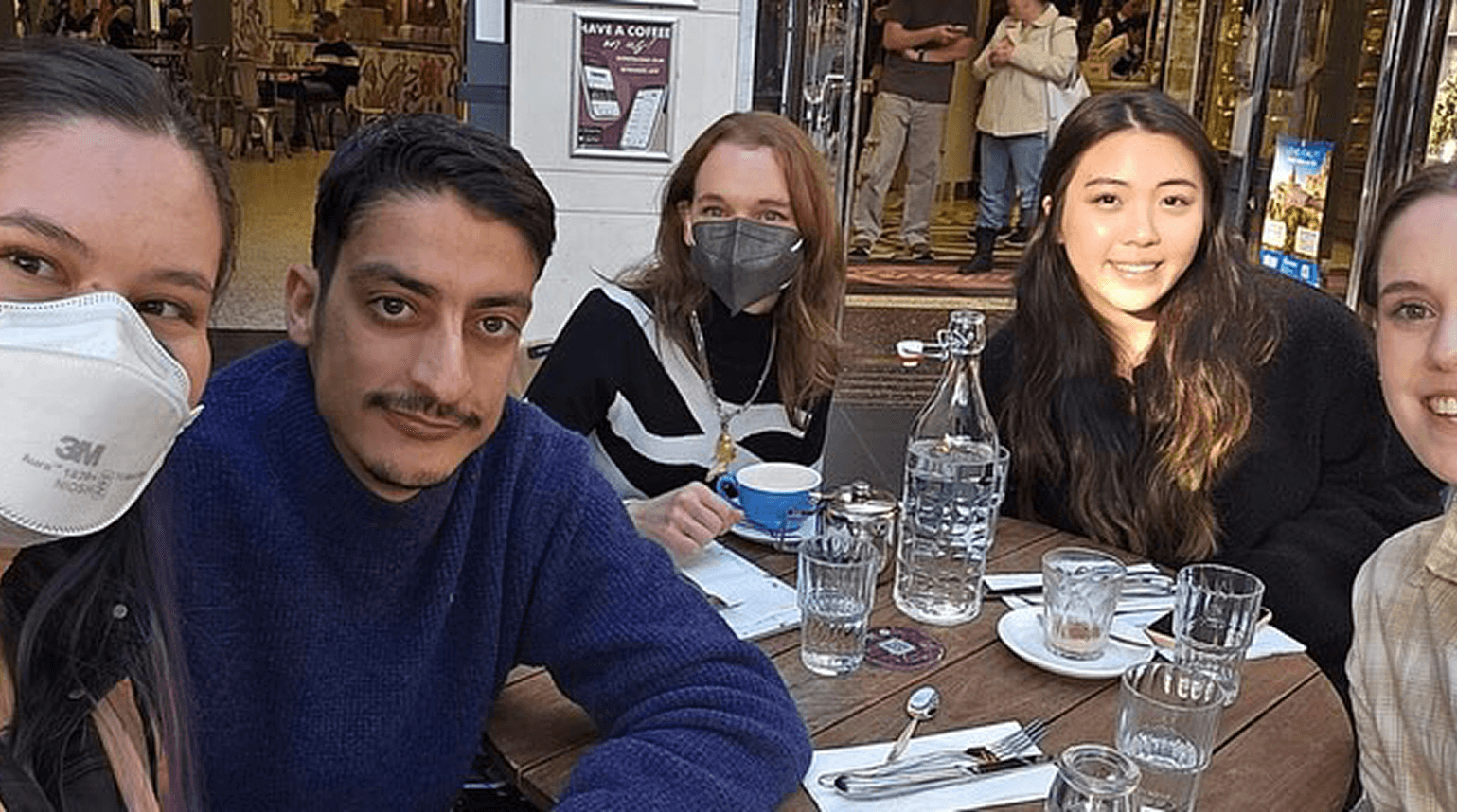 Group of people seated together at a cafe table